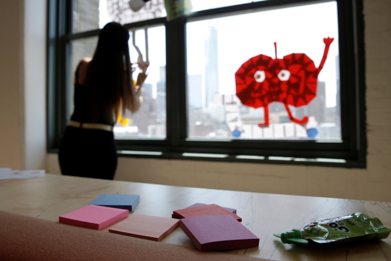 Image: Employee creates an image on a window with Post-it notes at the Horizon Media offices at 75 Varick Street in lower Manhattan, New York during \"Post-it note art war\"