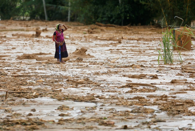 Image: Woman reacts as she inspects the site of a landslide at Elangipitiya village in Aranayaka