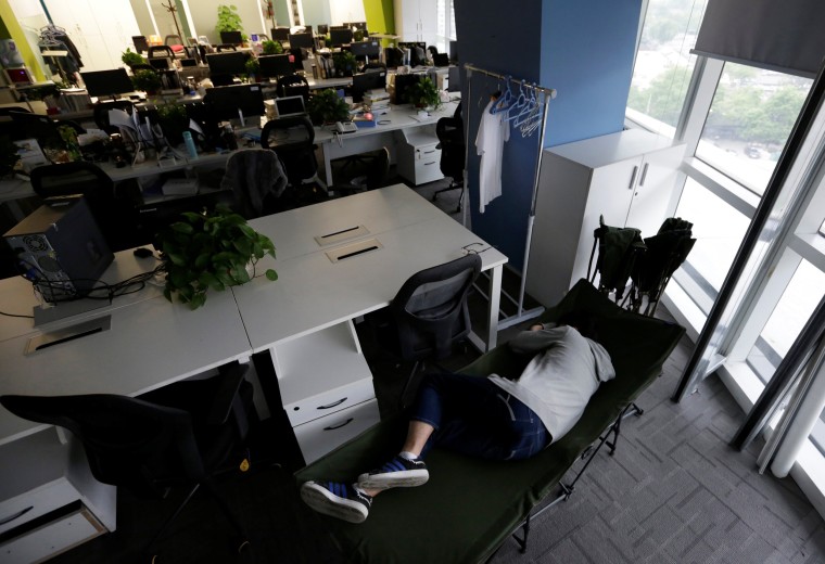 Image: The Wider Image: Working, eating and sleeping at the office
