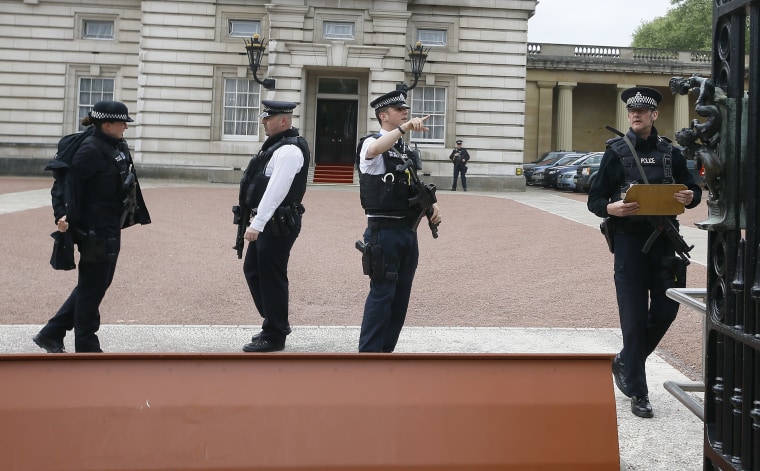 Image: Armed police officers work at the main gate of Buckingham Palace in London, Thursday, after a man climber over a wall.