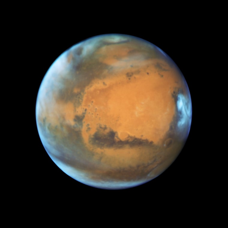 Mars as it was observed shortly before opposition in May 2016 by the Hubble Space Telescope. Some prominent features are clearly visible, including the heavily eroded Arabia Terra in the center of the image and the small southern polar cap.