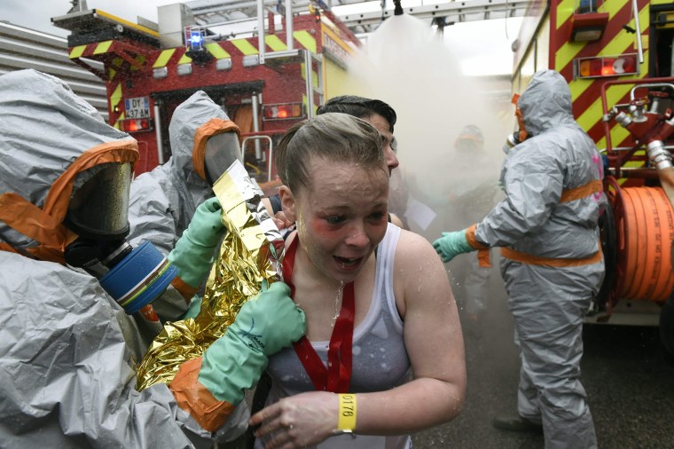 Image: Firefighters help "victims" during mock chemical attack exercise on April 4, 2016