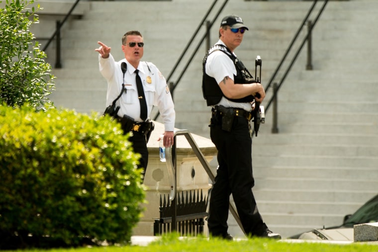 Image: A Secret Service agent orders people into buildings near the entrance to the West Wing