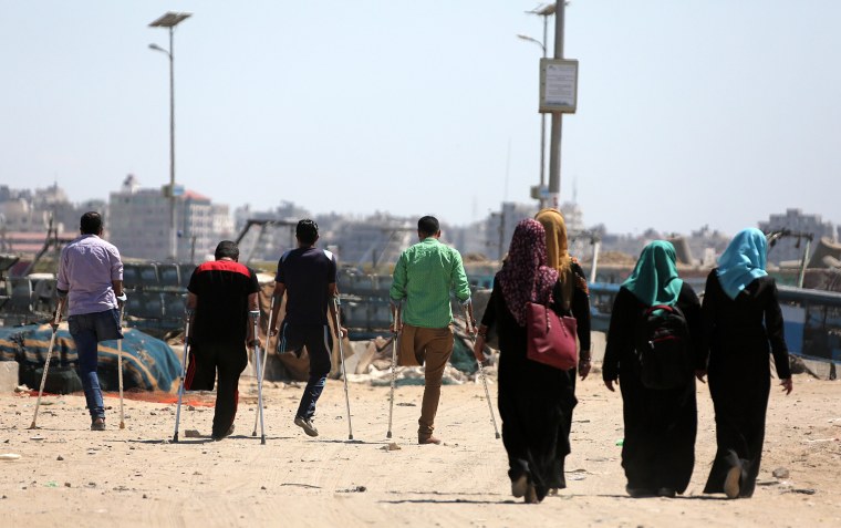 Image: Four Palestinian youths walk in the port of Gaza