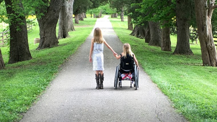 Eden and her older sister go for a stroll together.