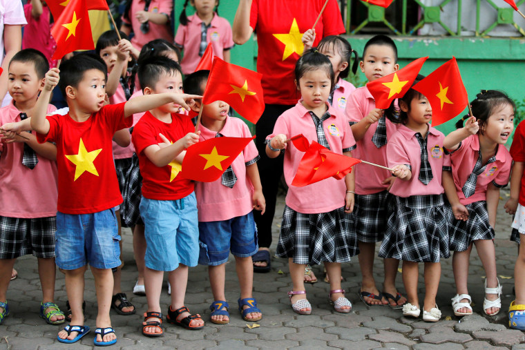 Image: Children look at the motorcade transporting U.S. President Barack Obama before an arrival ceremony at the presidential palace in Hanoi, Vietnam