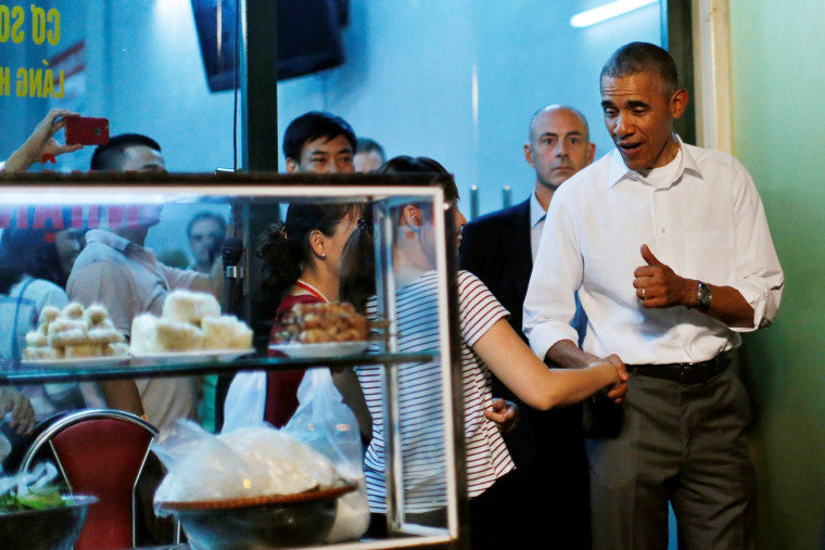 Image: U.S. President Barack Obama shakes hands with a local resident as he leaves after having a dinner with Anthony Bourdain at the restaurant in Hanoi