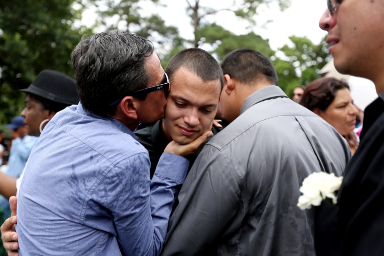 Juan Flores Jr., is comforted during a funeral service for his brother Josue Flores