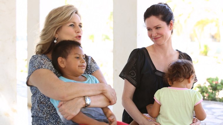 Cynthia McFadden (left) and Karen Spencer (right) sit with two children who live in one of the orphanages Karen's charity, Whole Child International, has worked to improve.