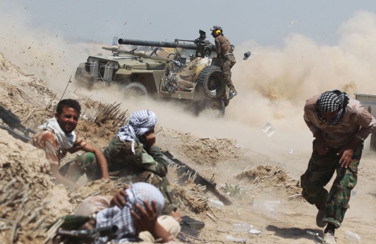 Image: Iraqi pro-government forces fire an anti-tank cannon near al-Sejar village