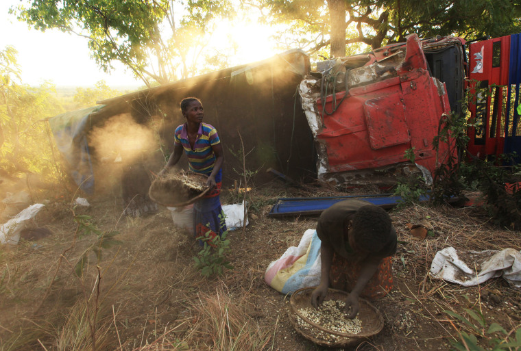 Image: Women and children separate grain from soil after a truck accident