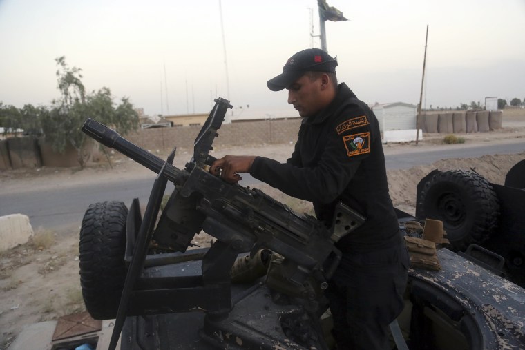 Image: A soldier prepares a heavy weapon at the operations center outside Fallujah