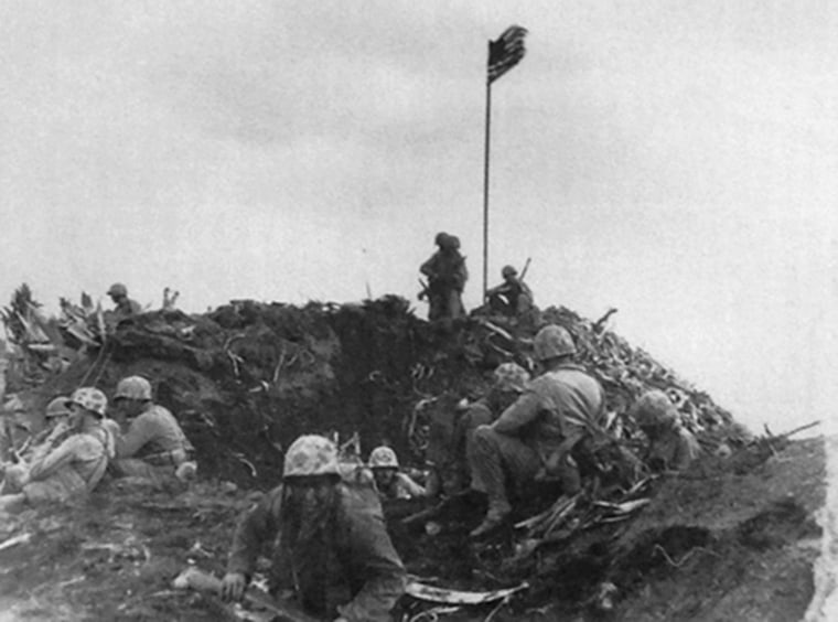 The first flag raised by U.S. troops on Iwo Jima's Mount Suribachi in this photo taken by Marine Sgt. Louis Burmeister.