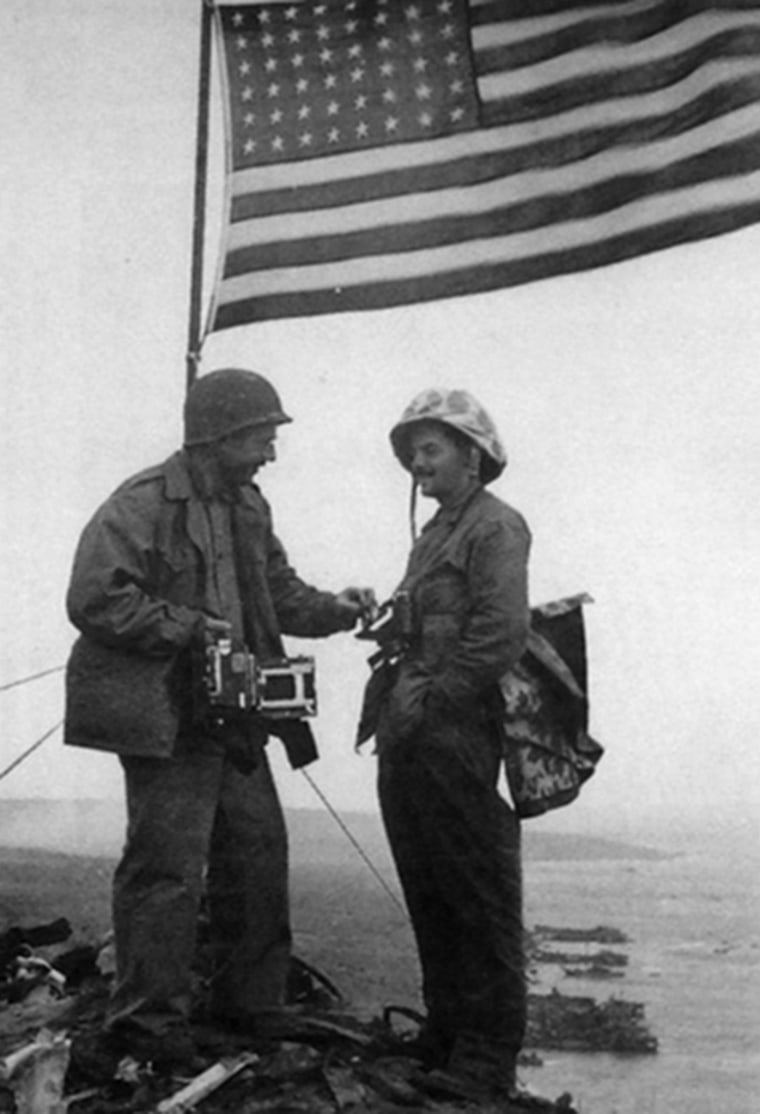 AP photographer Joe Rosenthal, left, and Army Pfc. George Burns pose under the second flag raised on Iwo Jima's Mount Suribachi.