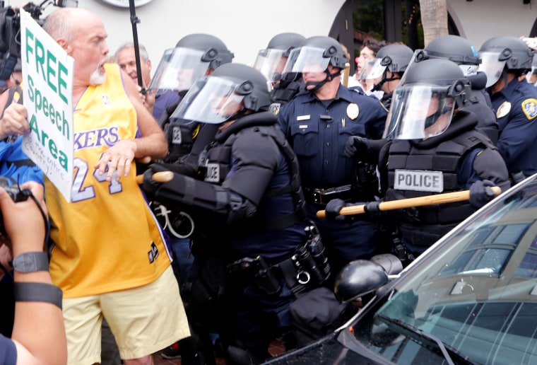 Image: Police push a man during a demonstration against Republican U.S. presidential candidate Trump outside his campaign event in San Diego