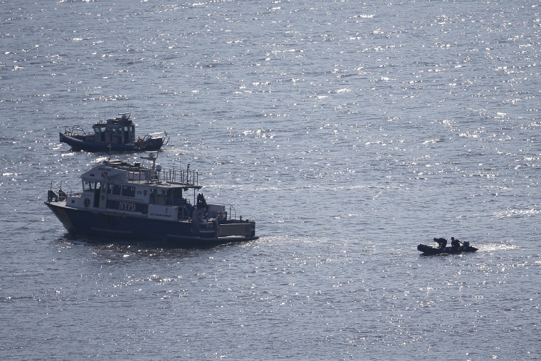 Image: NYPD divers ride a boat on the Hudson River