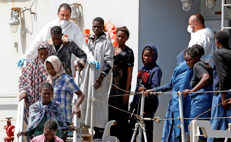Image: Migrants disembark from the Italian Navy vessel Vega at the Reggio Calabria harbour