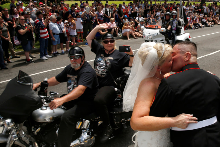 Image: Tim Chambers kisses his new bride Lorraine Heist as riders pass by during the Rolling Thunder motorcycle rally in Washington