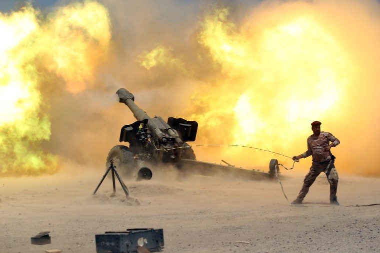 Image: A member of the Iraqi security forces fires artillery during clashes with Islamic State militants near Falluja