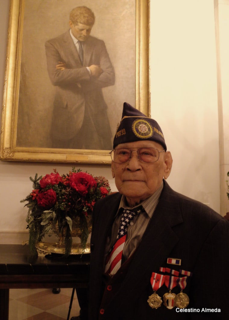 Celestino Almeda stands next to JFK portrait in Washington, D.C.