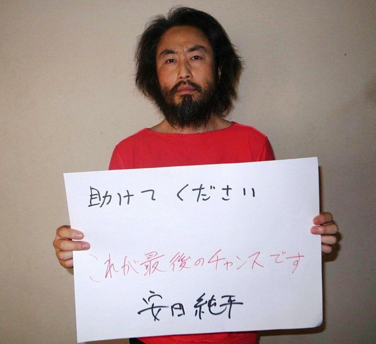 Image: The undated picture, released by Japan's Jiji Press news agency, purports to show Jumpei Yasuda holding a handwritten message.