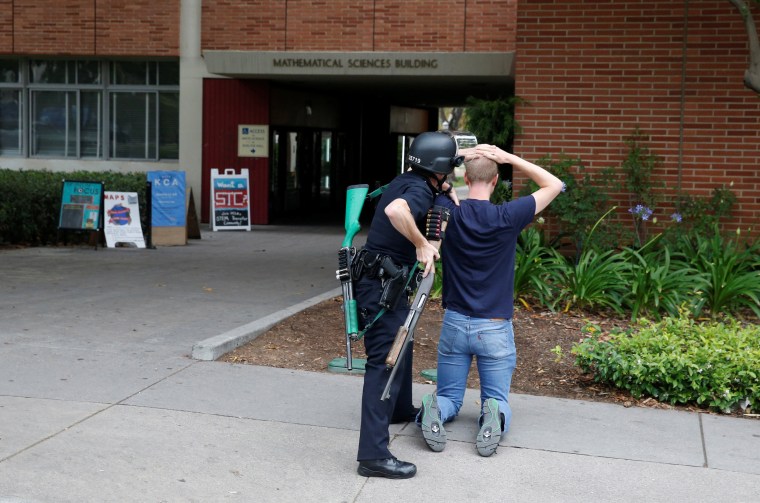 Image: A police officer searches a student at the University of California, Los Angeles campus after it was placed on lockdown following reports of a shooter on the campus in Los Angeles