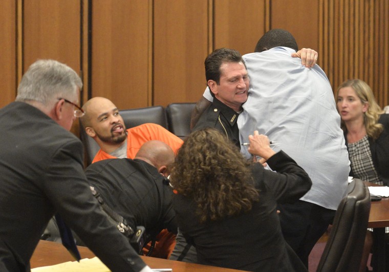 Image: A court officer tackles the father of one of three victims of Ohio serial killer Michael Madison