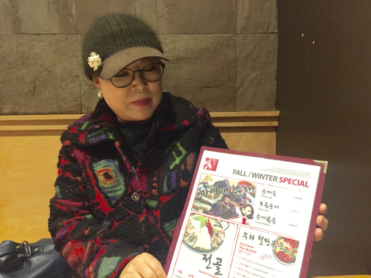 Youngae Ma with the menu featuring her North Korean-style sausages.