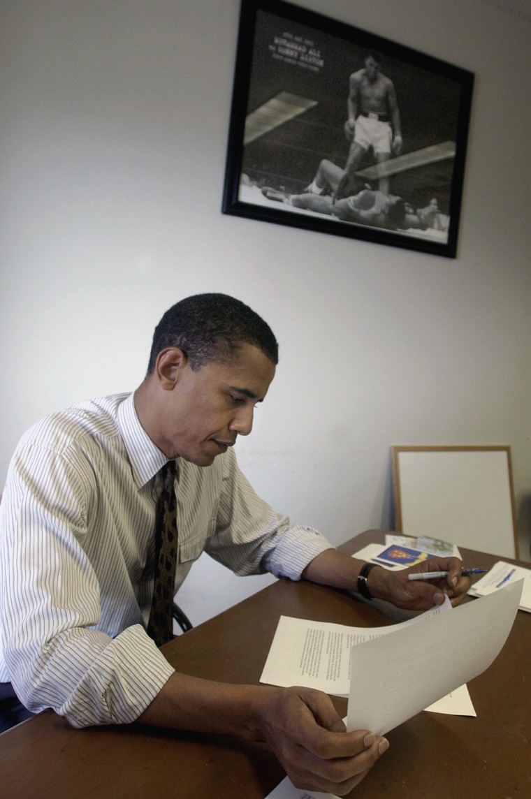 Image: Then-Democratic Senate nominee Barack Obama works near a photo of a victorious Muhammad Ali standing over his challenger