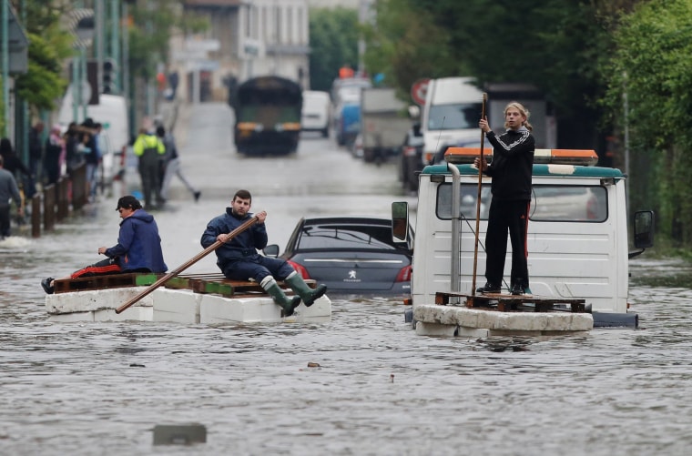Image: Residents who refused to be evacuated sit on makeshift boats during evacuation operations of the Villeneuve-Trillage flooded suburb in Villeneuve Saint-Georges