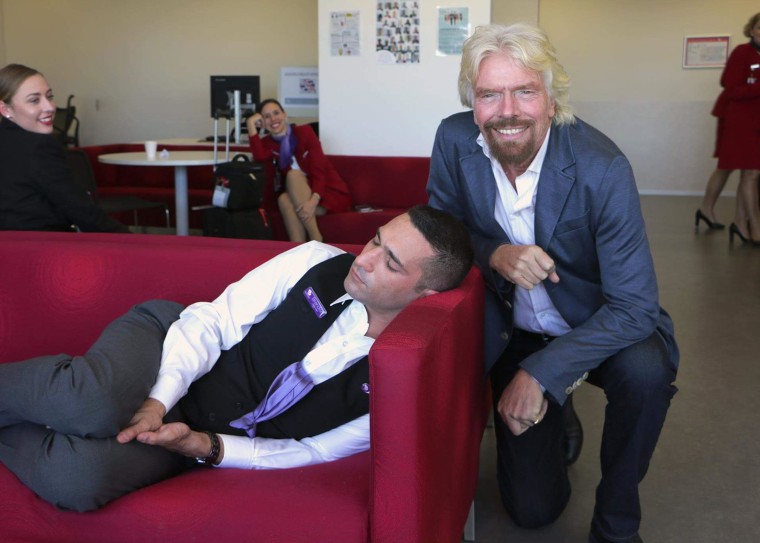 Richard Branson, mogul of Virgin everything, posed next to a sleeping employee in a fun blog post