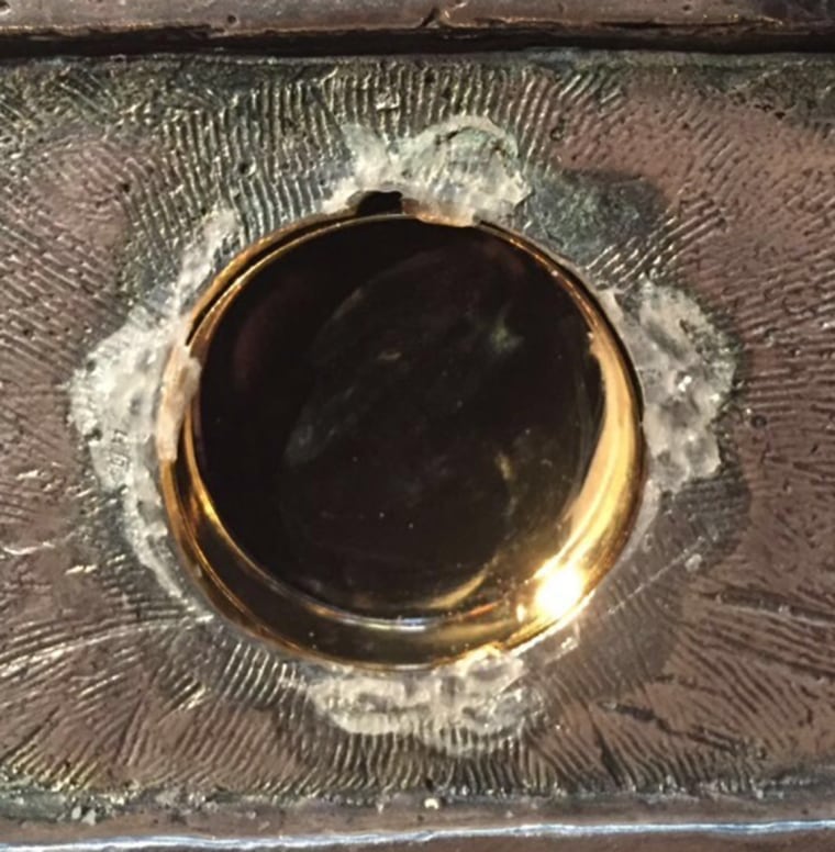 Image: Picture of the glass with a hole smashed by the thieves