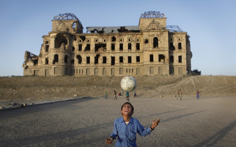 With collapsed roofs and bullet-strewn crumbling walls, the derelict Darul Aman Palace has become a symbol of failed attempts to bring peace to war-torn Afghanistan.
Above: Afghan children play soccer in front of the war-damaged Darul Aman Palace in the suburbs of Kabul, Afghanistan, on June 8, 2011.