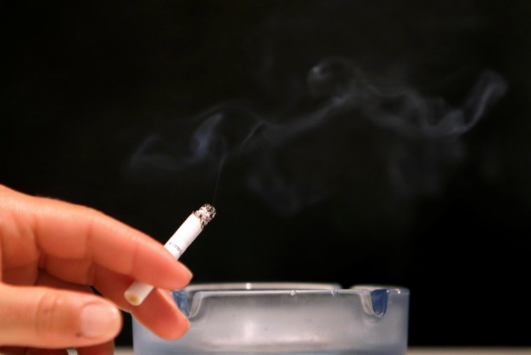 Image: A customer smokes a cigarette in a cafe