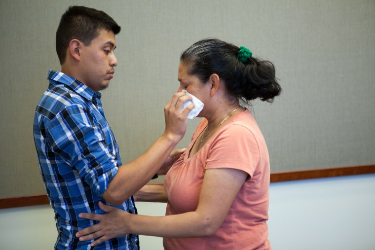 Image: Steve Hernandez wipes a tear from his mother's eye after seeing her for the first time in 20 years