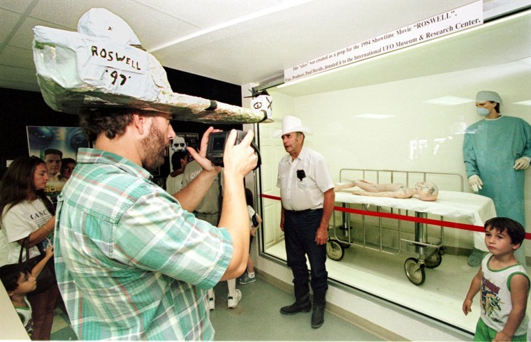 A visitor wearing a home-made hat takes pictures o