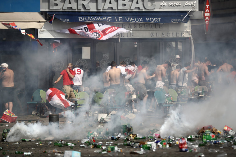 Image: England fans react after police sprayed tear gas during clashes