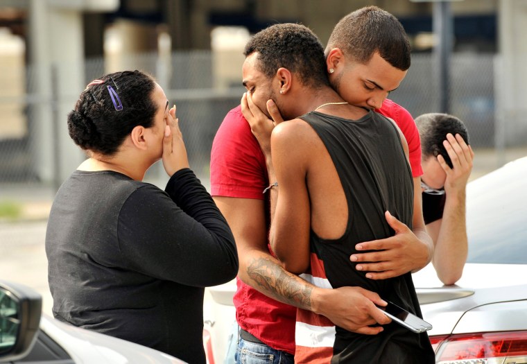 Image: Friends and family members embrace outside the Orlando Police Headquarters during the investigation of a shooting at the Pulse night club in Orlando, Florida