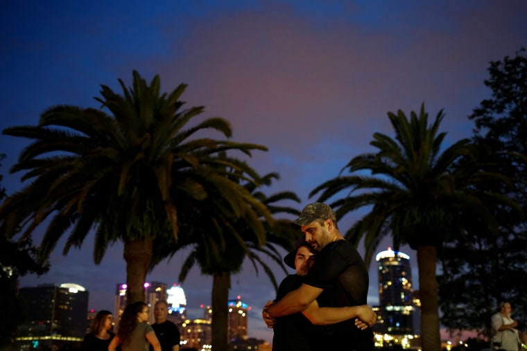 Image: Partners embrace during vigil to commerate victims of a gay night club shooting in Orlando, Florida