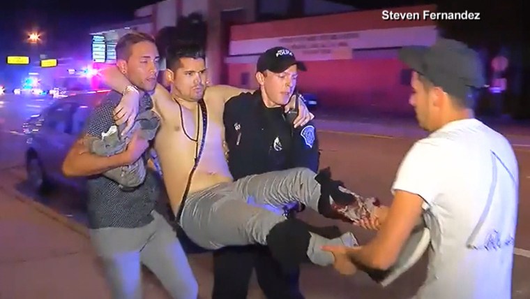 An Orlando police officer helps a wounded victim of the LGBT nightclub shooting