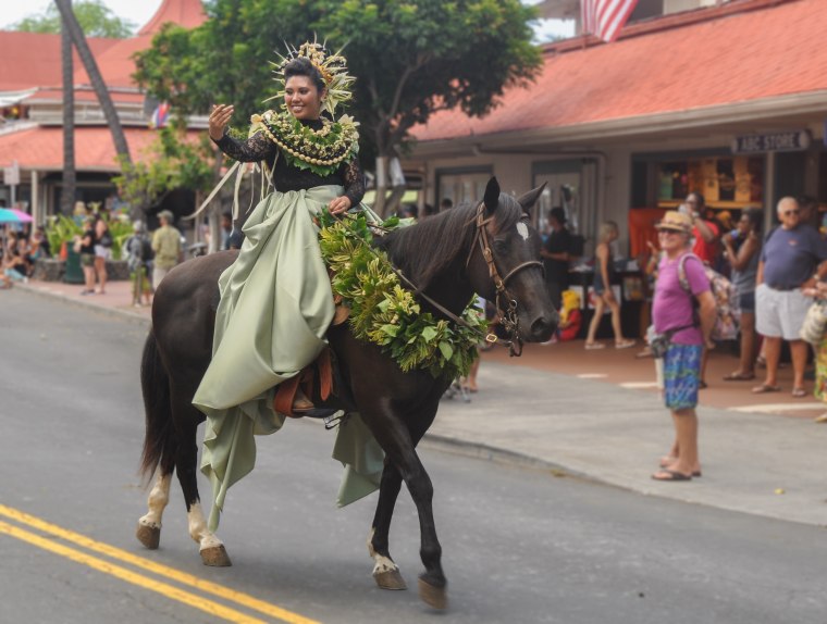 Cheyenne Fuerte, the pa'u princess representing the Island of Moloka'i at the 2016 Kona-Kailua's King Kamehameha Day Celebration Parade. Fuerte's leis are made of kukui nut and her pa'u attire is green, which represents the flora and colors of that island