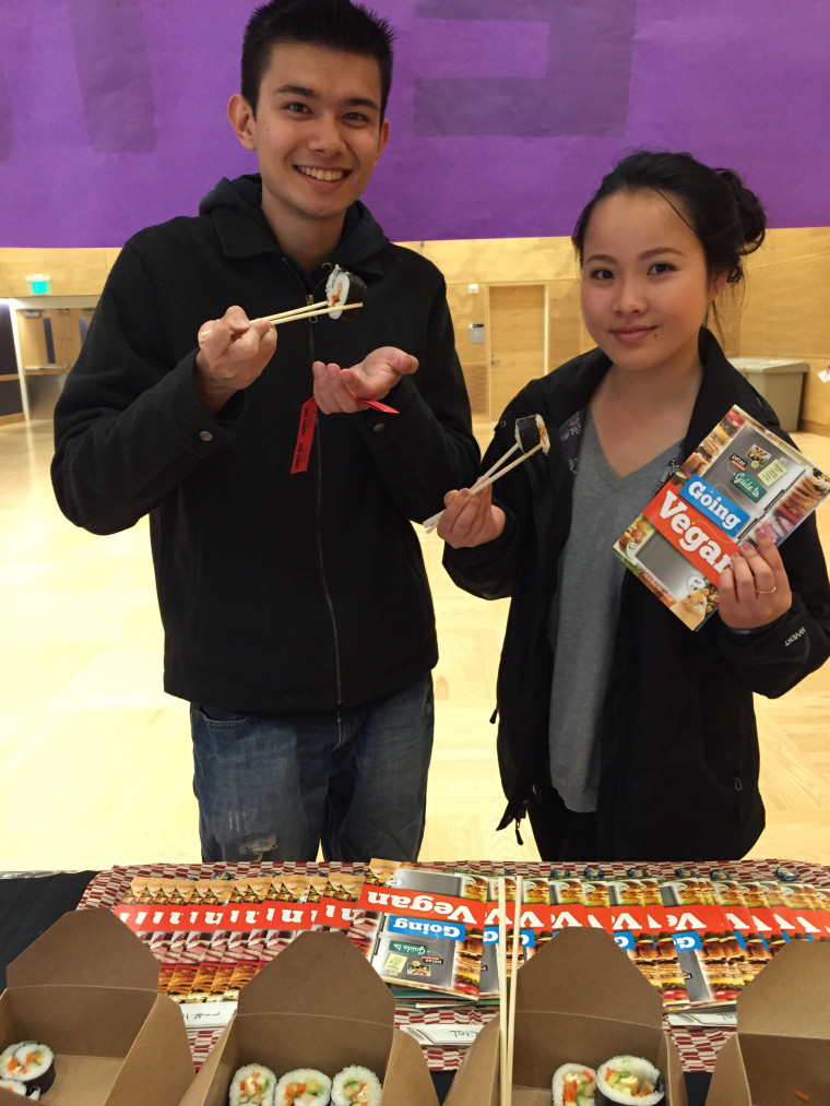 Students eating vegan sushi from a peta2 table.