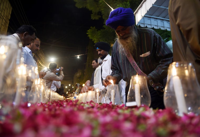 Image: Pakistani supporters of Muttahida Qaumi Movement (MQM) light candles in Karachi