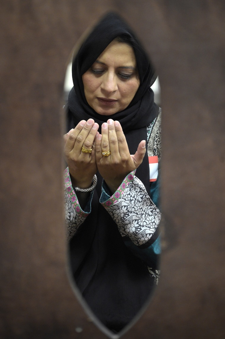 Image: Saima Qureshi prays during a special prayer with non-Muslim members