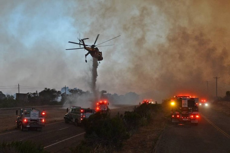 Image: A sky crane helicopter makes a drop as the Sherpa Fire burns