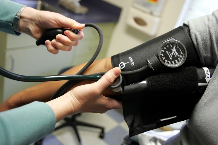 Doctor measuring patient's blood pressure.