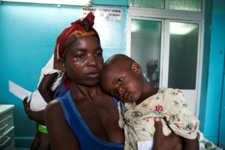 A mother holds her child suffering from yellow fever at a hospital in Luanda