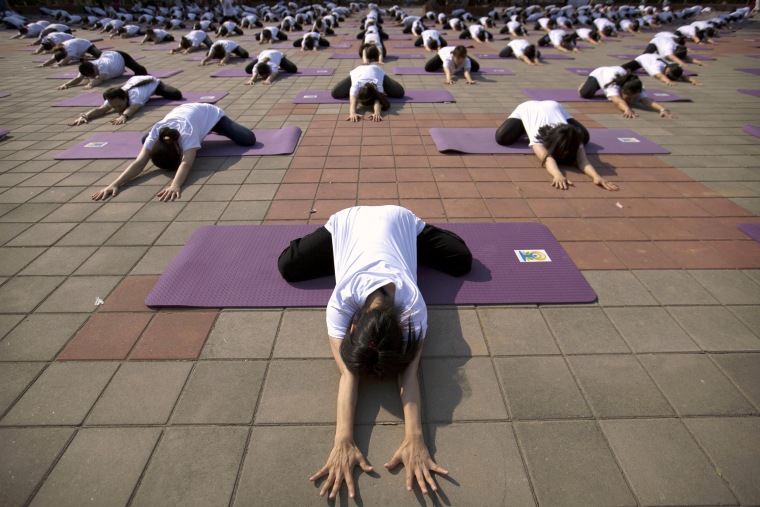 Image: Participants strike a pose during a group yoga session at a park in Beijing