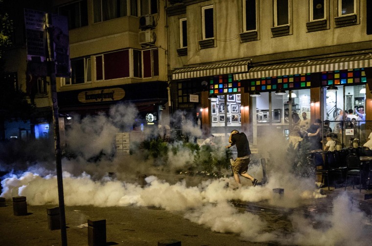 Image: A man runs away as Turkish anti riot police use tear gas to disperse protesters