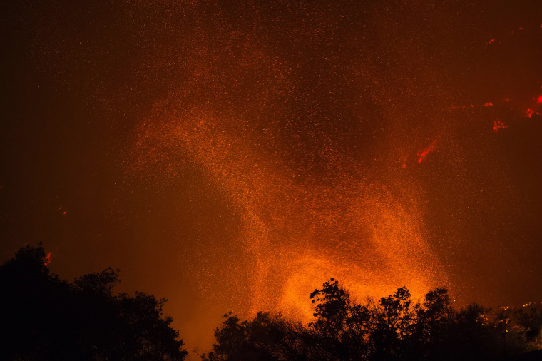 Image: A fire whirl, or fire tornado, rises from advancing flames in the early morning hours